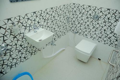 ein Badezimmer mit Waschbecken und Toilette in der Unterkunft Ichhepuron in Shānti Niketan