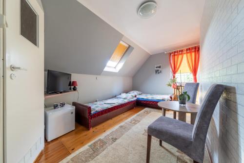 Dormitorio pequeño en el ático con cama y mesa en Pokoje Gościnne Szpak, en Białowieża