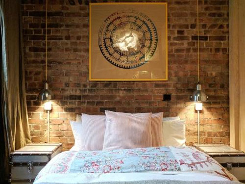 a bedroom with a brick wall and a bed at Stylish 1 bed with large plant filled garden in London