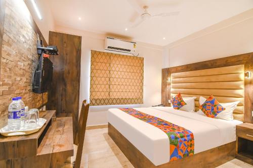 a hotel room with a bed and a television at FabHotel Prime The Pavilion in kolkata
