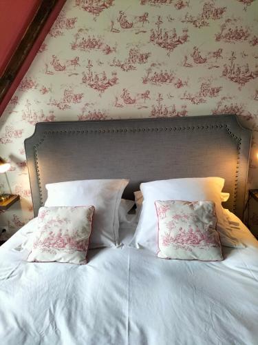 a bed with white sheets and pillows in a bedroom at Chambres d'Hôtes Le Grismoustier in Veulettes-sur-Mer