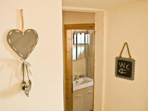 uma decoração de coração na parede de uma casa de banho em Theano Cottage em Gaios