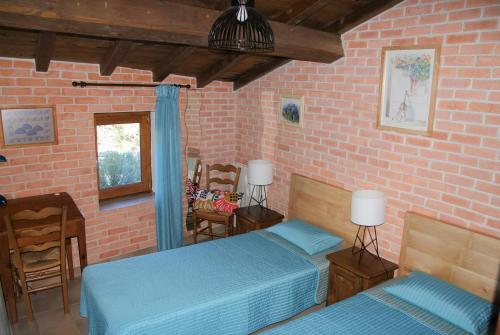 1 dormitorio con 2 camas y pared de ladrillo en Côté Séranne, en Saint-André-de-Buèges