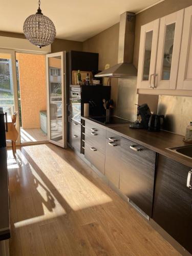 une cuisine avec des armoires blanches et un plancher en bois dans l'établissement Sevrier, appartement 73M2 avec terrasse , 4pers, à Sévrier