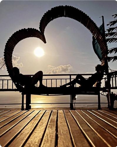 a couple of people laying on a bench on a pier at Exotic Stay Koh Tao in Koh Tao