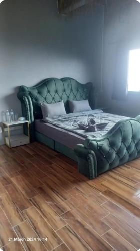 Exotic Stay Koh Tao في كو تاو: سرير في غرفة مع أريكة جلدية خضراء
