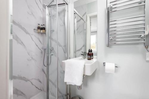 y baño blanco con lavabo y ducha. en Monksholm House - Sleeps 10 - 5 Mins from St Andrews en St Andrews