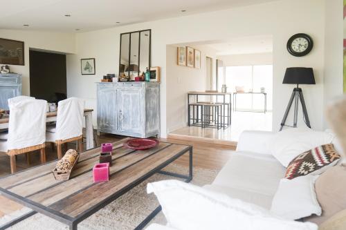 un salon avec un canapé blanc et une table dans l'établissement Jolie maison rénovée proche centre ville Les Sables 9 personnes, à Les Sables-dʼOlonne