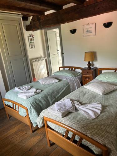 two twin beds in a room with wooden floors at Affittacamere Coletti in Fabbrica