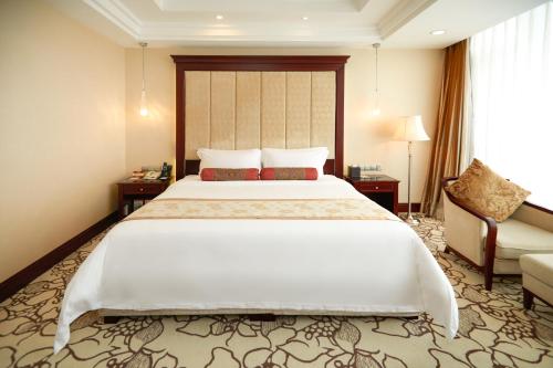 a bedroom with a large white bed and a couch at Soluxe Hotel Guangzhou - Overseas Buyers Registration Service&Canton Fair Free Shuttle Bus 15 Oct to 04 Nov in Guangzhou