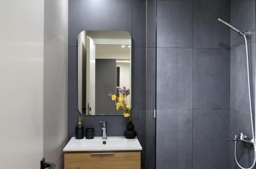 a bathroom with a sink and a mirror at T&N Central Amazing Apartment in Thessaloniki