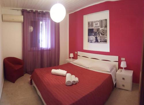 1 dormitorio rojo con 1 cama y 2 toallas blancas en resort eloisa, en Balestrate