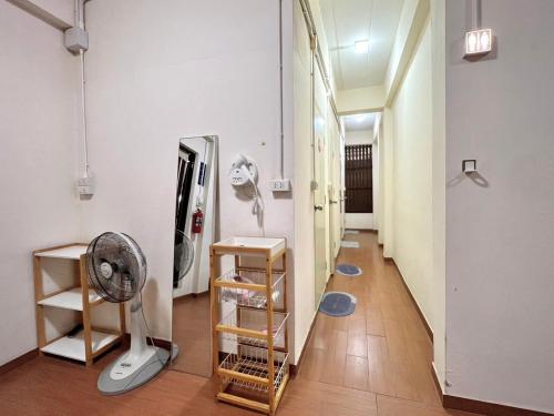 a hallway with a mirror and a fan at Allred Hostel Chiangmai in Chiang Mai