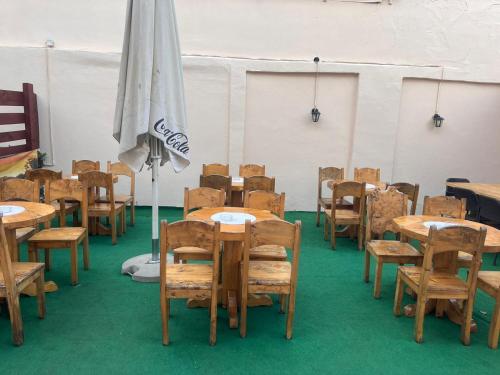 une chambre avec des tables, des chaises et un parasol dans l'établissement Restoran i prenoćište Begović, à Požega