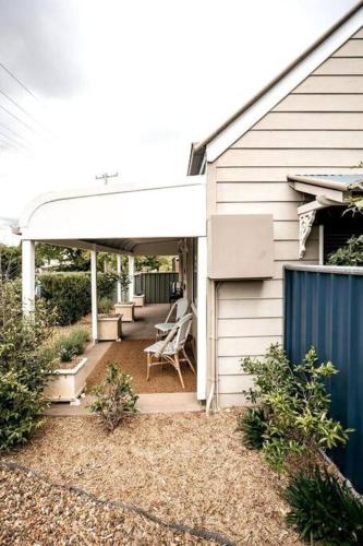a porch of a house with a white pergola at The Icely Cottage in Orange
