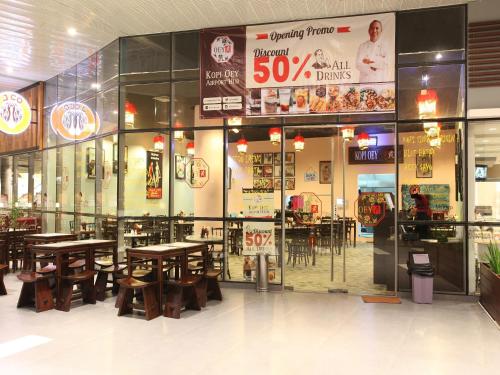 a restaurant with tables and chairs inside of it at Zest Airport Jakarta by Swiss-Belhotel International in Tangerang