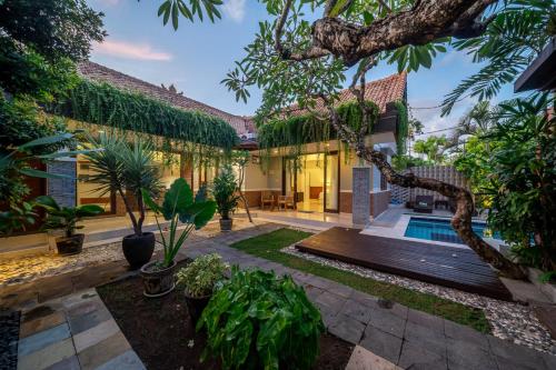 - une vue sur l'extérieur d'une maison avec une piscine et des plantes dans l'établissement Nameera Villa, à Seminyak