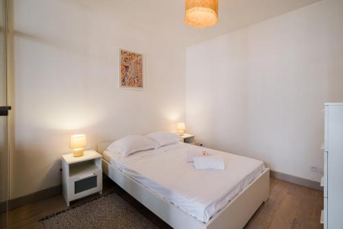 - une chambre blanche avec un lit et deux lampes dans l'établissement Quiet central Lyon AIL, à Lyon