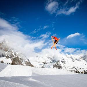 a kite flying in the sky over a snow covered mountain at MAISON DU BOURG in Courmayeur