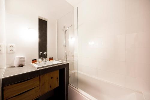 La salle de bains blanche est pourvue d'un lavabo et d'une douche. dans l'établissement Large duplex in the heart of Old Lyon, à Lyon