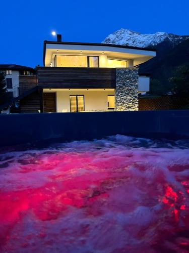 a house with a pool of pink water in front of it at La villa del lago in terrazzo in Colico