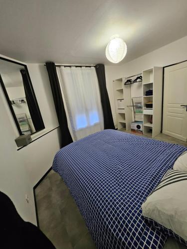 a bedroom with a blue and white bed and a window at Maison bordeaux lac in Bordeaux