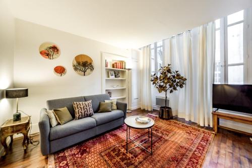 salon z kanapą i telewizorem w obiekcie Un havre de paix au cœur de Lyon AIL w mieście Lyon