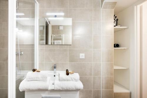 une salle de bain avec un lavabo et un miroir dans l'établissement Appartement au cœur du 6ème arrondissement AIL, à Lyon