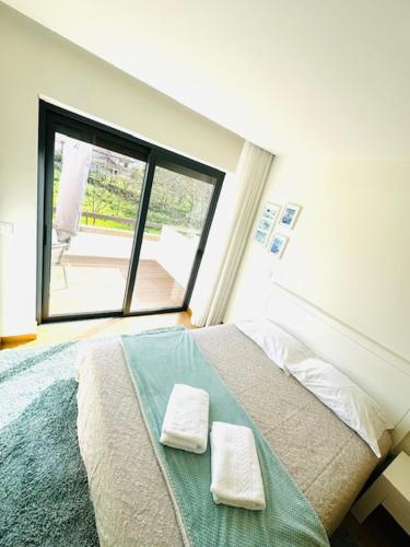 a bedroom with a bed with two towels on it at Casa do Carvalho - Ponte de Lima in Ponte de Lima
