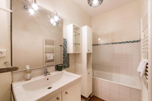 une salle de bain blanche avec un lavabo et une douche dans l'établissement Escale cosy proche gare Part Dieu AIL, à Lyon