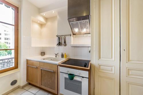 une cuisine avec un évier et une cuisinière dans l'établissement Escale cosy proche gare Part Dieu AIL, à Lyon