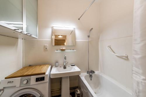 une salle de bain avec un lavabo et une machine à laver dans l'établissement Spacieux et lumineux 70m² de la place AIL, à Lyon