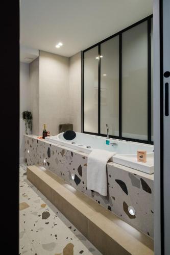 une salle de bain avec deux lavabos et un grand miroir dans l'établissement La Balnéo des Terreaux AIL, à Lyon