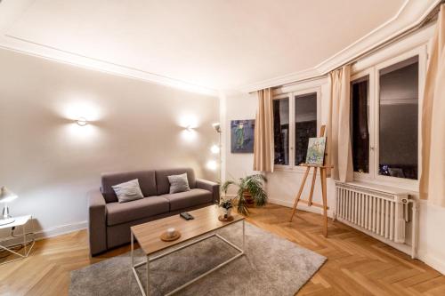 un salon avec un canapé et une table basse dans l'établissement Spacieux et lumineux 70m² de la place AIL, à Lyon