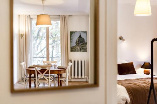 Cette chambre comprend une table, un lit et un miroir. dans l'établissement Spacious and bright 70m² square AIL, à Lyon