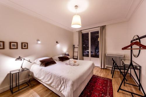 - une chambre avec un lit blanc et un tapis rouge dans l'établissement Spacieux et lumineux 70m² de la place AIL, à Lyon