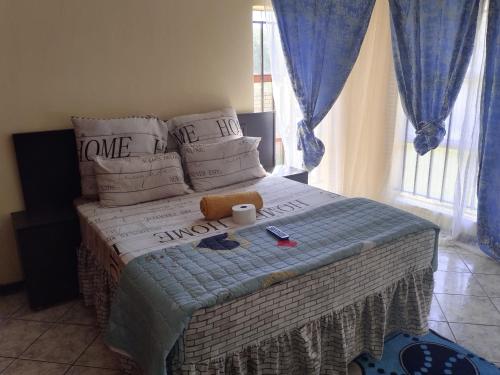 a bed with a teddy bear sitting on top of it at COMFORT ZONE GUEST HOUSE in Zeerust