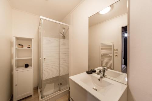 een witte badkamer met een wastafel en een douche bij Le Canut - Quiet AIL in Lyon