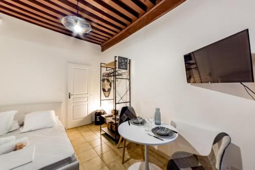 Il comprend un salon doté d'une table blanche et d'une télévision. dans l'établissement Le Canut - Quiet AIL, à Lyon