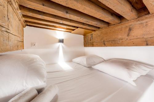 a bed with white sheets and pillows in a room at Ideal studio in the heart of Lyon AIL in Lyon
