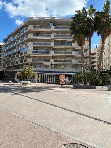 a large building with palm trees in front of it at Apartamentos Amatista in Salou