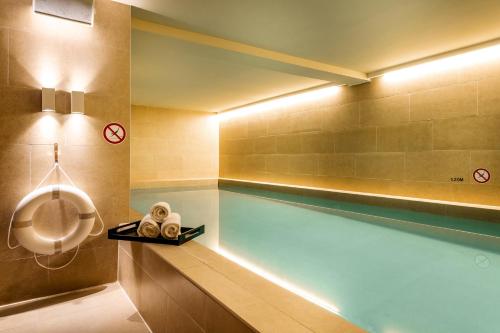 a swimming pool with a tub in a bathroom at Pestana Amsterdam Riverside in Amsterdam