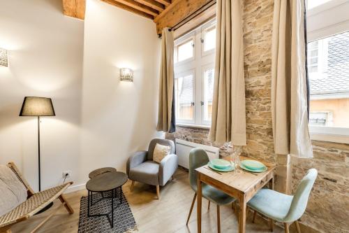 uma sala de estar com mesa e cadeiras em Cozy studio in the heart of Lyon - Cordeliers AIL em Lyon