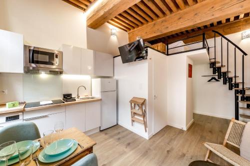 une cuisine et une salle à manger avec une table et des chaises dans l'établissement studio de charme au cœur de Lyon AIL, à Lyon