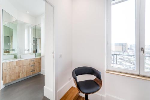 - une chaise noire dans la salle de bains pourvue d'une fenêtre dans l'établissement Appartement MODERNE- Lyon Part-Dieu - Dreamy Flat Lyon, à Lyon