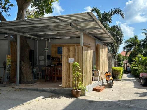 eine hölzerne Pergola mit einem Motorrad, das darunter geparkt ist in der Unterkunft The Sea Resort Haad Rin in Haad Rin