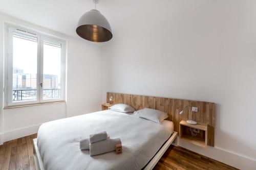 une chambre blanche avec un grand lit et une fenêtre dans l'établissement Appartement MODERNE- Lyon Part-Dieu - Dreamy Flat Lyon, à Lyon