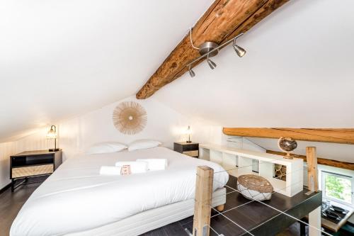 une chambre avec un lit blanc et des plafonds en bois dans l'établissement Le loft des artistes de la Croix-Rousse AIL, à Lyon