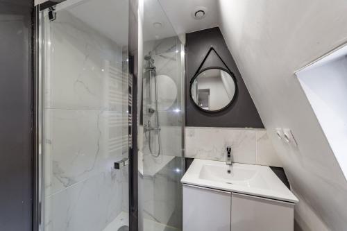 La salle de bains est pourvue d'une douche, d'un lavabo et d'un miroir. dans l'établissement Central Studio Jacobins AIL, à Lyon