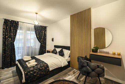 um quarto com uma cama, um espelho e uma cadeira em WES Apartment Grand Park em Cluj-Napoca